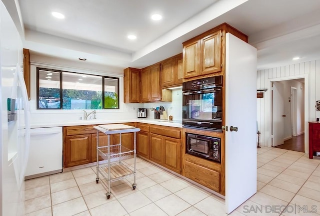 kitchen with black appliances, light tile patterned floors, and sink