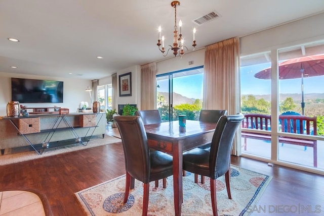 dining room featuring hardwood / wood-style floors, a mountain view, and a chandelier