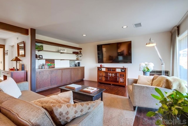 living room with beamed ceiling and dark hardwood / wood-style flooring