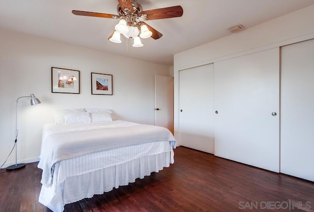 bedroom with ceiling fan, dark hardwood / wood-style flooring, and a closet