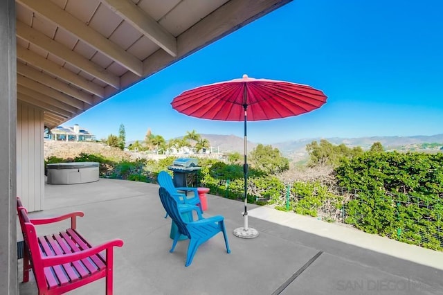 view of patio featuring a mountain view and a hot tub