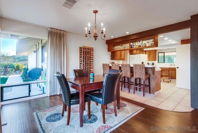 dining room featuring a notable chandelier and light wood-type flooring