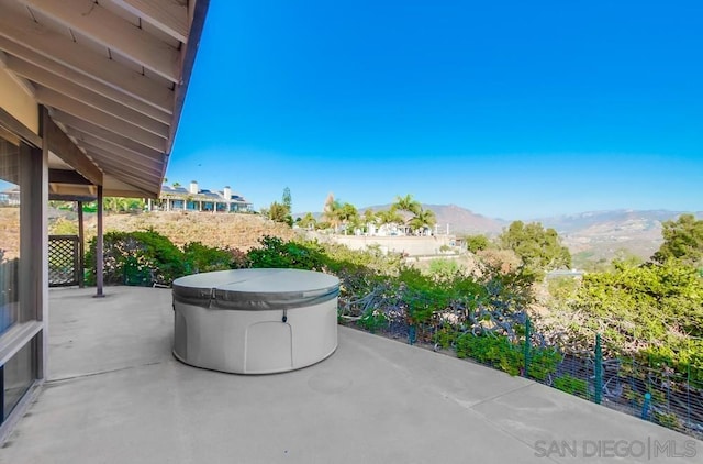 view of patio / terrace featuring a mountain view and a hot tub