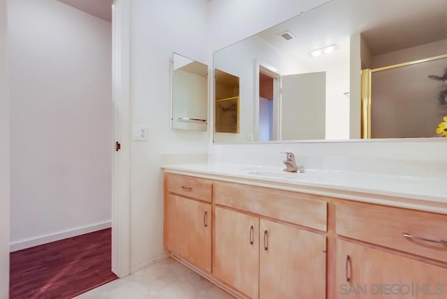 bathroom featuring hardwood / wood-style floors, vanity, and a shower with door