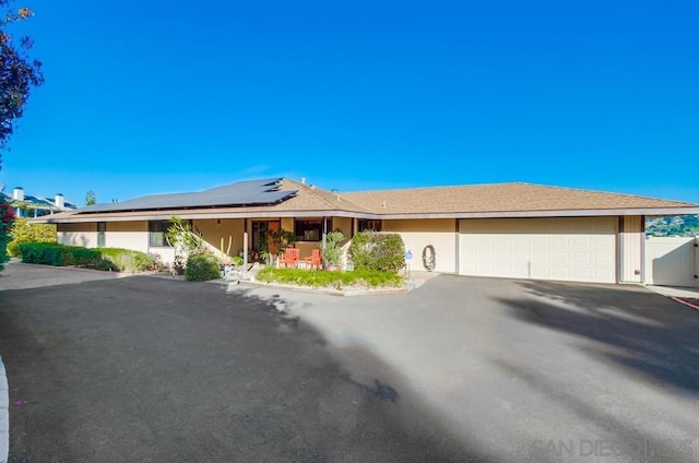 ranch-style house featuring solar panels and a garage