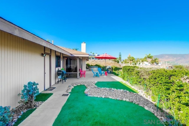 view of yard featuring a mountain view and a patio area