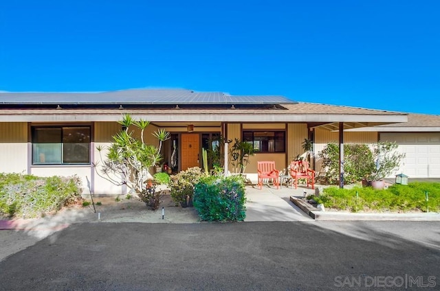 view of front of home featuring a porch and solar panels