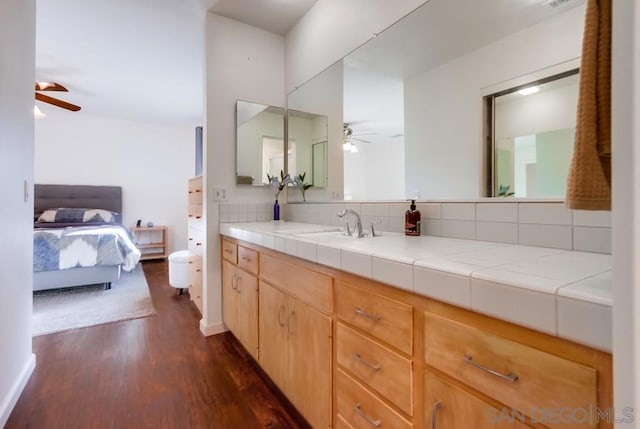 bathroom with tasteful backsplash, ceiling fan, hardwood / wood-style floors, and vanity