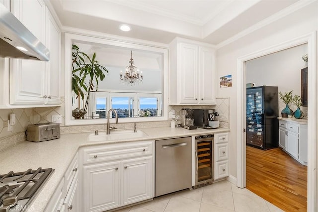 kitchen with appliances with stainless steel finishes, beverage cooler, and white cabinets