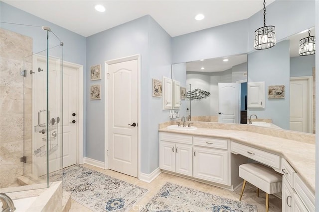 bathroom featuring a shower with shower door, vanity, and a notable chandelier