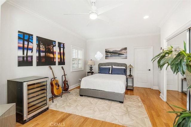 bedroom featuring ceiling fan, wine cooler, hardwood / wood-style flooring, bar, and ornamental molding