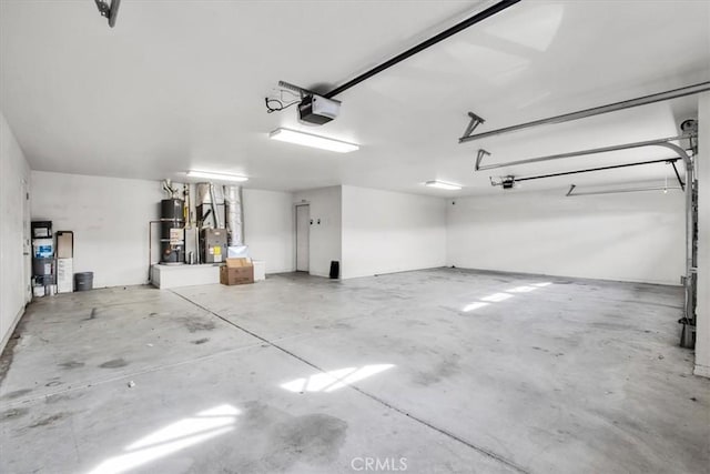 garage featuring strapped water heater and a garage door opener