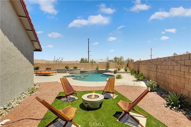 view of pool with a lawn, a patio area, and a fire pit