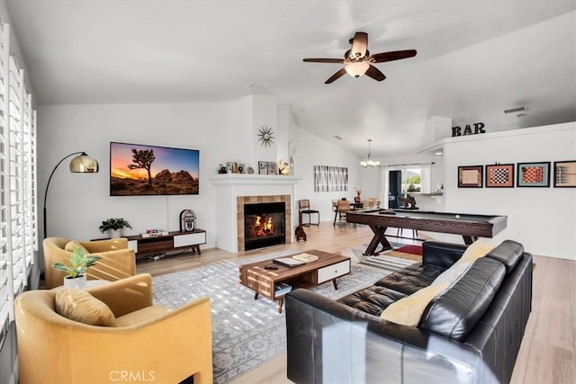 living room with a fireplace, hardwood / wood-style floors, lofted ceiling, and pool table