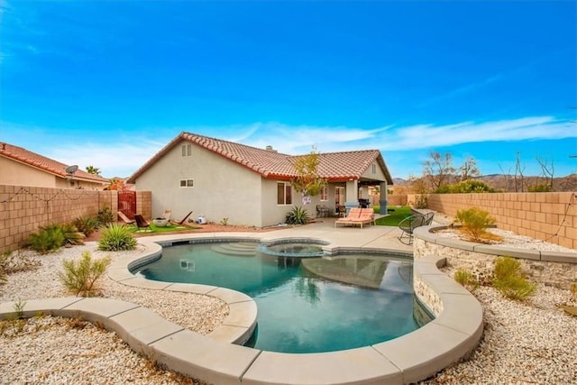 back of house featuring a patio and a pool with hot tub