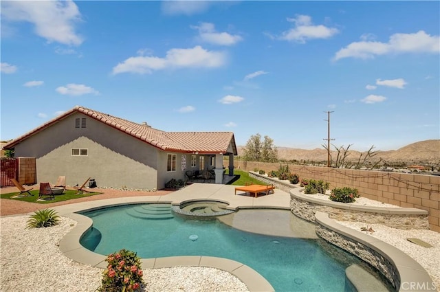 view of pool featuring a mountain view, an in ground hot tub, and a patio