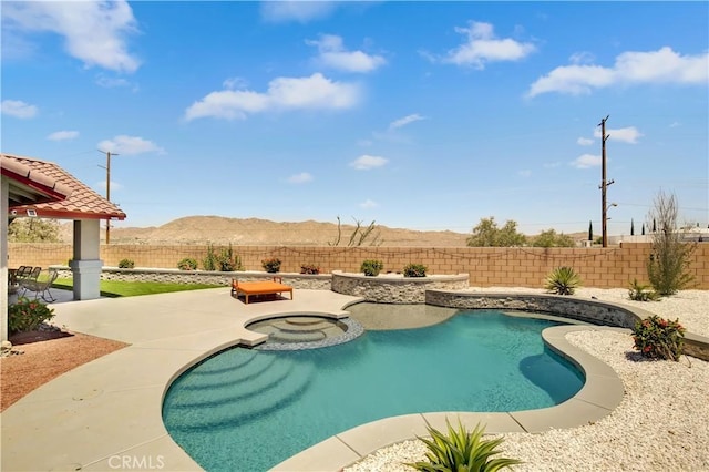 view of pool featuring an in ground hot tub, a mountain view, and a patio area