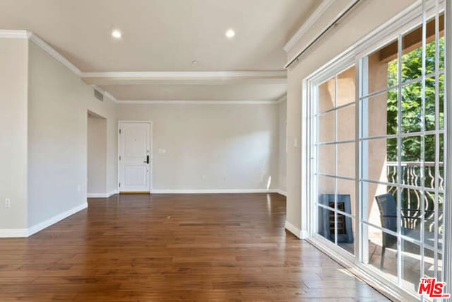 spare room featuring dark hardwood / wood-style floors and ornamental molding