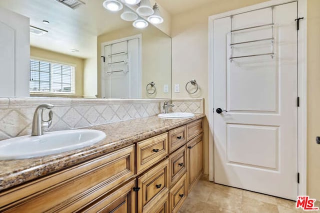 bathroom with vanity and decorative backsplash