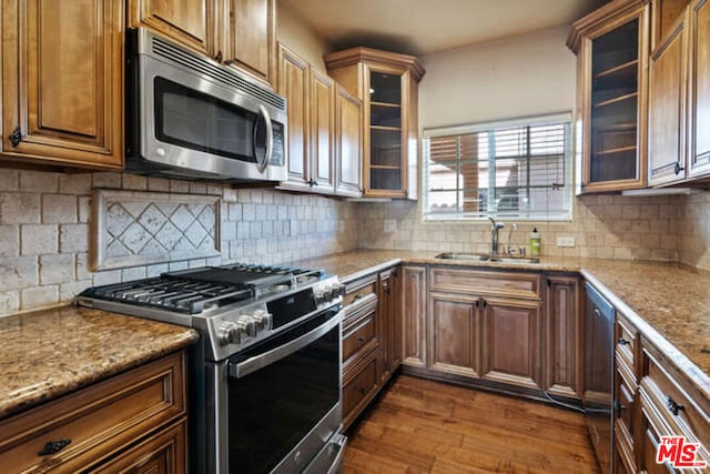 kitchen featuring tasteful backsplash, sink, stainless steel appliances, and light stone countertops