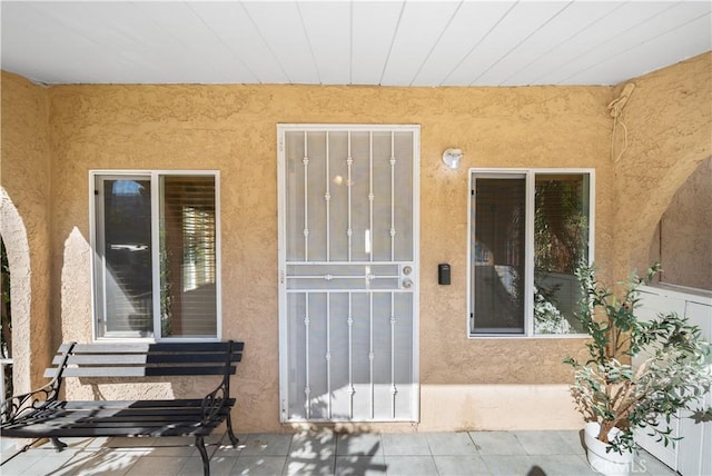 view of exterior entry with a patio area