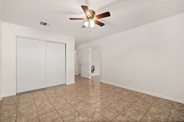 unfurnished bedroom with ceiling fan and a closet