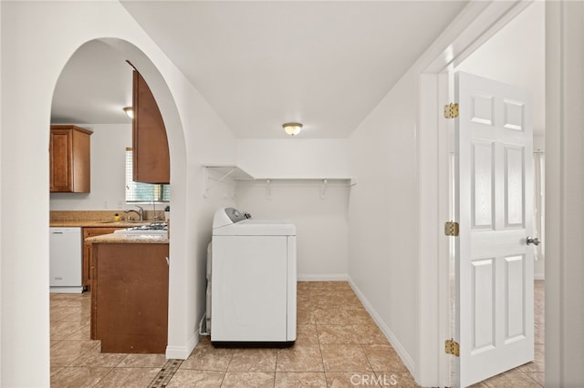 interior space with sink, light tile patterned flooring, and washer / dryer