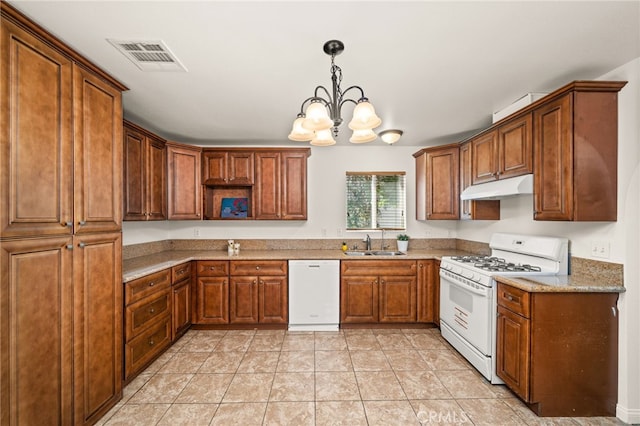 kitchen with pendant lighting, white appliances, sink, light stone counters, and a chandelier