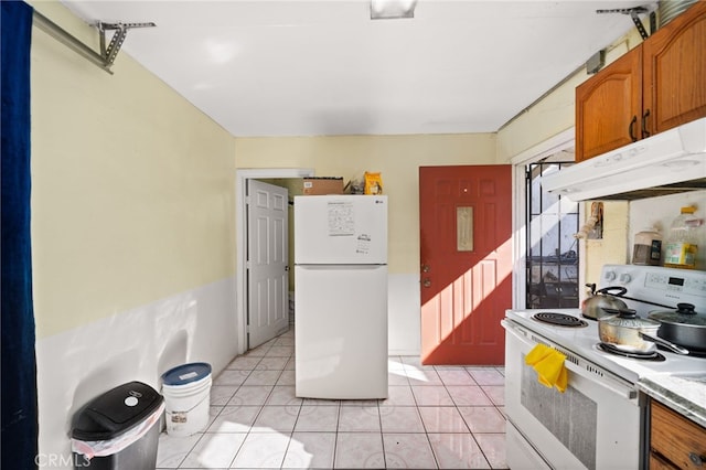 kitchen with light tile patterned flooring and white appliances