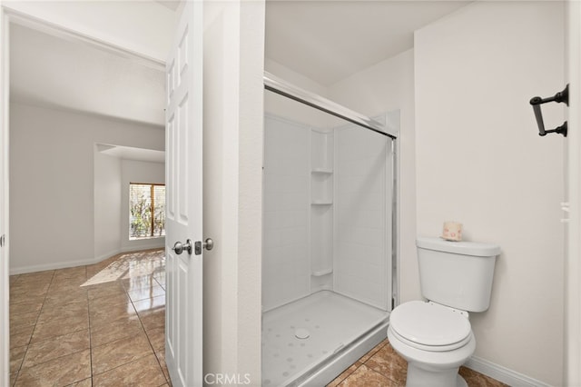 bathroom featuring tile patterned floors, a shower with shower door, and toilet