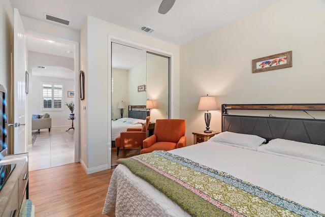 bedroom with ceiling fan, light wood-type flooring, and a closet