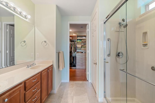 bathroom featuring tile patterned flooring, vanity, and a shower with door