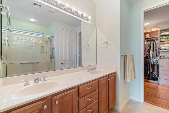 bathroom with hardwood / wood-style flooring, vanity, and an enclosed shower