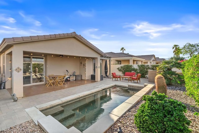 rear view of house featuring an outdoor living space, a fenced in pool, ceiling fan, and a patio area