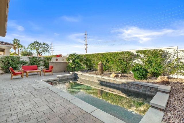 view of swimming pool featuring an outdoor living space and a patio area