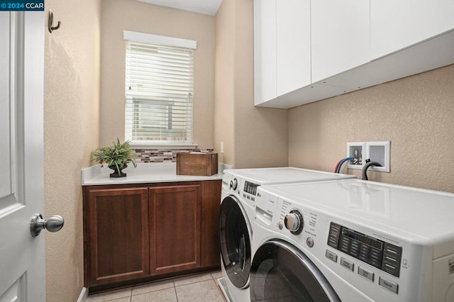 laundry area featuring cabinets, light tile patterned floors, and washing machine and dryer