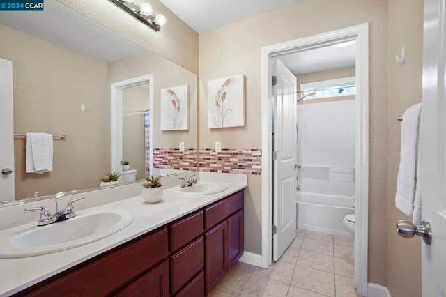 bathroom with tasteful backsplash, vanity, tile patterned flooring, and toilet