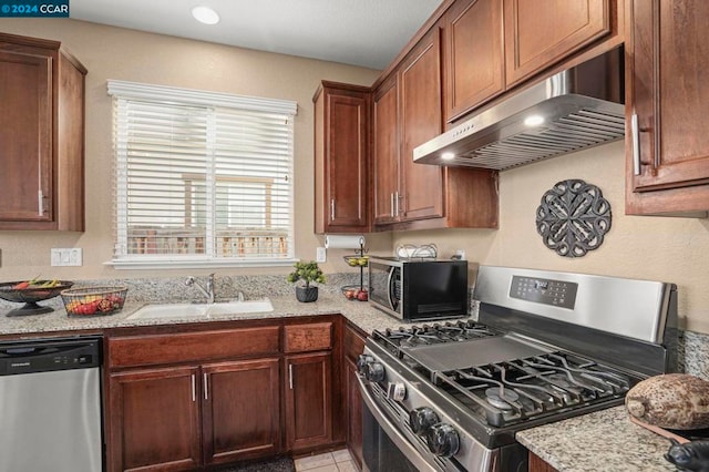 kitchen featuring extractor fan, sink, light tile patterned flooring, light stone countertops, and stainless steel appliances