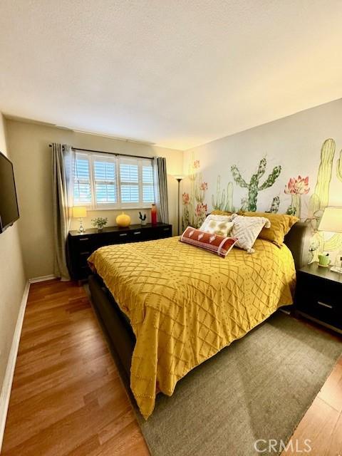 bedroom with wood finished floors and baseboards