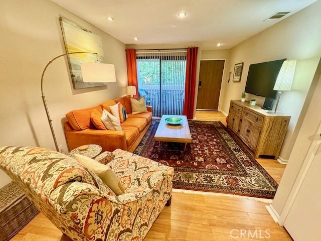 living area featuring recessed lighting, visible vents, light wood-style flooring, and baseboards