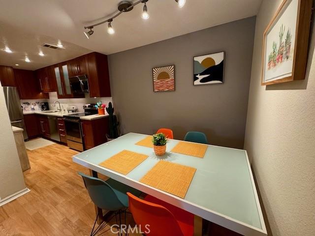 dining area with light wood-style floors and visible vents