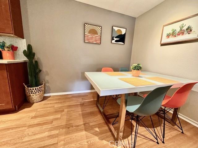 dining space with baseboards and light wood-style floors