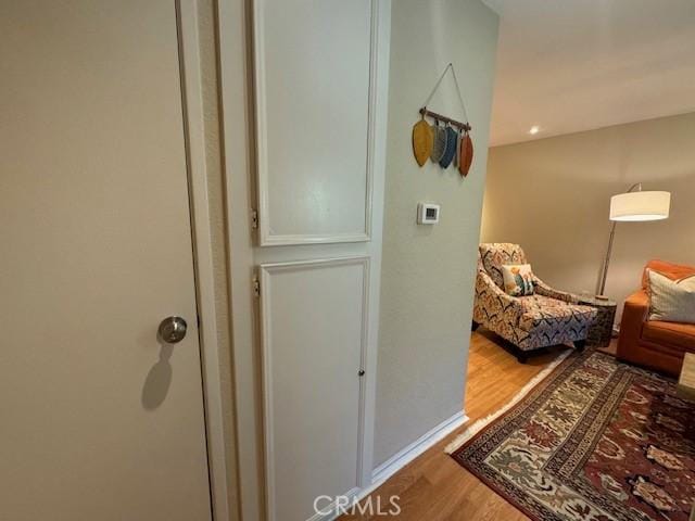 hallway featuring wood finished floors and baseboards