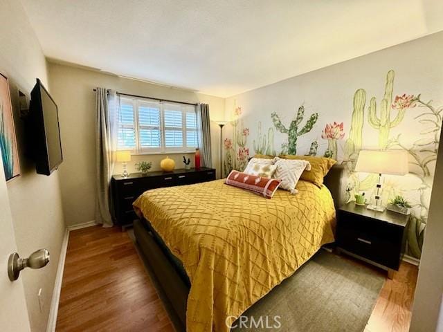 bedroom with baseboards and dark wood-style flooring