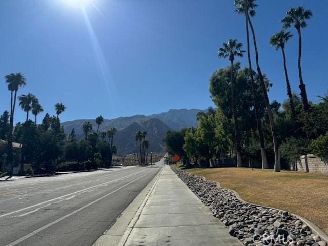 view of street with sidewalks, traffic signs, and a mountain view