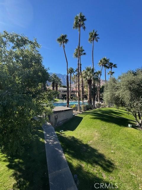 view of home's community with a swimming pool and a yard