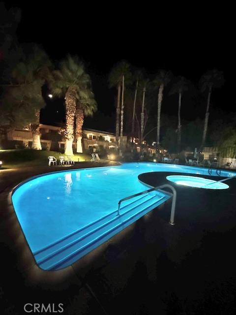 2810 N Arcadia Ct Unit 208, Palm Springs, CA 92262 - pool at night featuring a community pool and a patio