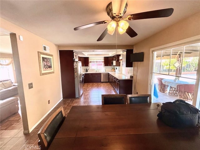 dining area with ceiling fan, plenty of natural light, and sink