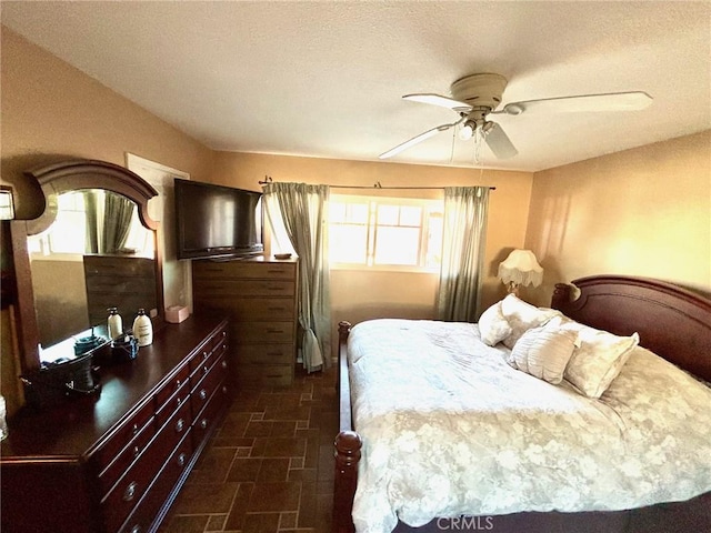 bedroom with ceiling fan and a textured ceiling