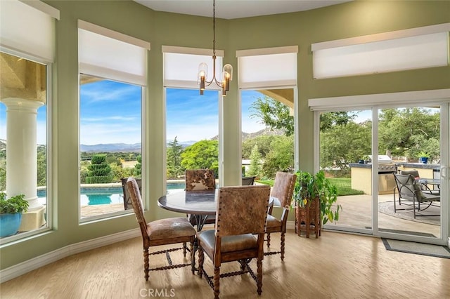 sunroom / solarium featuring a chandelier